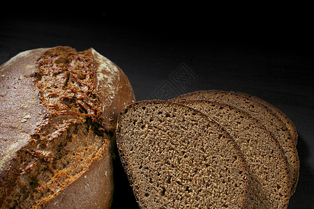 木制桌上的切黑面包木板收获小麦大麦杂货店碳水营养化合物食物桌子图片