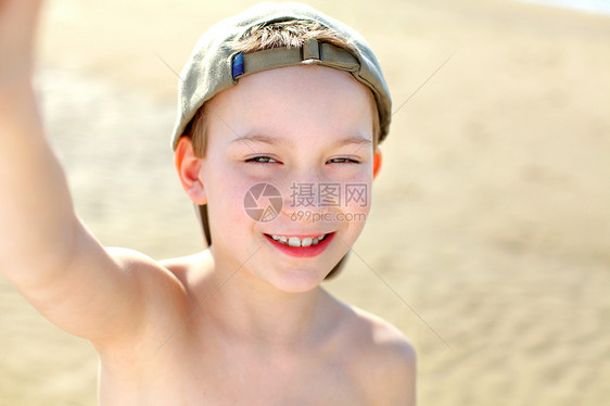 男孩在海滩上青少年男生帽子海浪阳光快乐运动喜悦手势牙齿图片