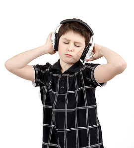 一个快乐的小男孩的肖像 用耳机收听音乐唱歌白色童年微笑技术卡拉ok工作室黑色幸福乐趣图片