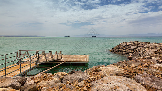 红海边的甲板海岸天空蓝色树叶木头岩石支撑图片