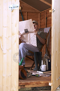 男人在花园小棚里读书工具园艺木头退休花园躺椅孤独报纸家庭生活学习图片