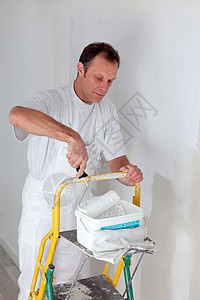 装饰师画一个房间白色和滚筒梯子油漆工概念工业创造力房屋维修工具男人装修图片