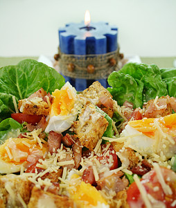 凯撒沙拉和蜡烛刀具熏肉设置西红柿用餐烹饪草药午餐桌面营养图片