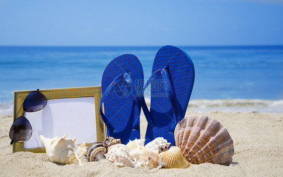 沙沙滩上带照相机和贝壳的滑坡拖鞋和贝壳旅游框架太阳镜照片蓝色记忆木板旅行相框海滩图片