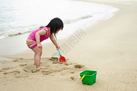 海滩的托德勒玩具女性假期晴天海岸线孩子微笑海洋喜悦太阳图片