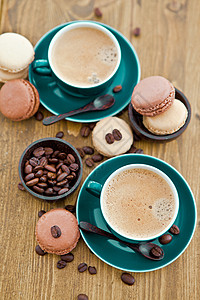热咖啡和法国马卡龙饮料饼干款待勺子绿色咖啡糖果杯子图片