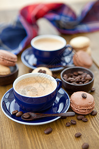 热咖啡和法国马卡龙糖果杯子咖啡勺子饮料款待餐巾蓝色饼干图片