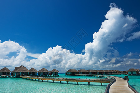 美丽的海滩 有水边的平房情调蓝色房子旅行码头异国海洋平台热带天空图片