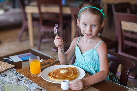 可爱的小女孩在度假餐厅吃早饭 很可爱孩子假期桌子童年女孩快乐小吃早餐女性酒店背景图片
