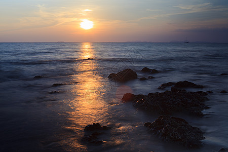 沙滩上有海蓝天空的岩石天气海洋波浪地平线海岸天空石头海滩日落蓝色图片