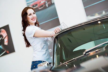 站在汽车旁边的年轻妇女微笑女性女孩车库蓝色客户商业司机车辆驾驶图片