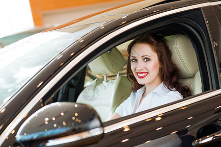 女青年在展厅的新车里汽车女士旅行乐趣学习司机欢乐成就手指学习者图片