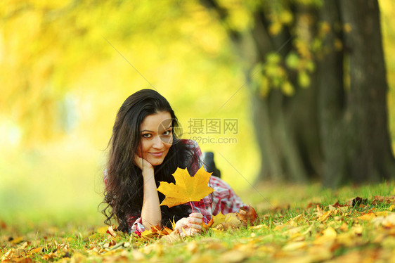 秋叶中的妇女脚尖微笑季节女性毛衣女孩乐趣幸福公园团体头发图片