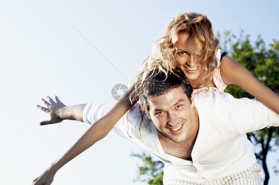 在天空中拥抱蓝色喜悦季节女性场地妻子快乐情人男人成人图片