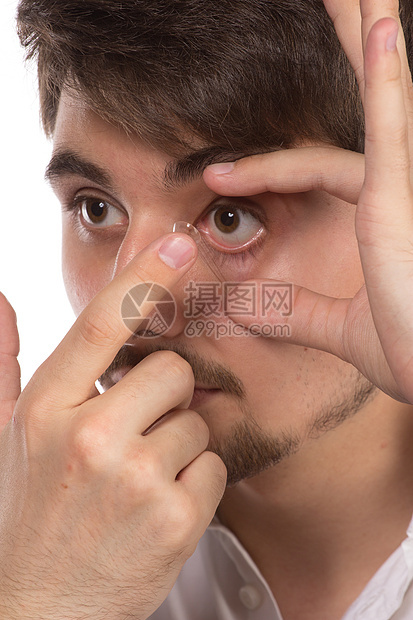 在插入纠正性c时 对男子棕色眼睛的近视蓝色眼镜清洁镜头手指男人宏观眼球角膜验光图片