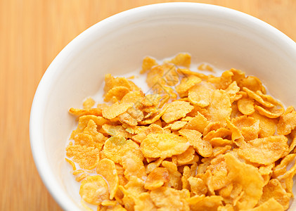 玉米片在碗中谷物奶制品白色饮食粮食黄色薄片早餐食物木头图片