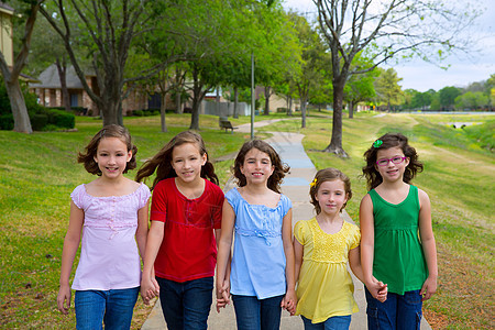 姐妹女孩和朋友儿童群体在公园中行走朋友们草地家庭幸福孩子们派对女性童年团体假期图片