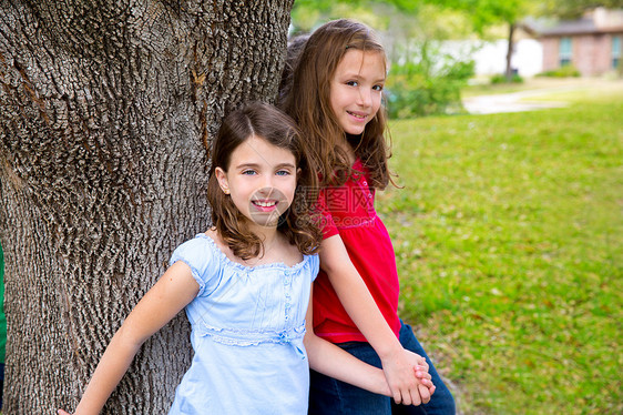 儿童团体朋友女孩在树上玩耍孩子们女性孩子树干美丽女孩们牛仔裤眼睛朋友们幸福图片