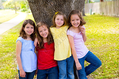儿童团体朋友女孩在树上玩耍草地女孩们蓝色幸福孩子们树干眼睛树木公园友谊图片