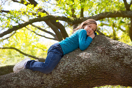 躺在树枝上躺着的女女童公园女性季节童年喜悦女儿花园金发乐趣孩子图片