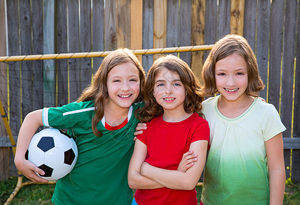 三个姊妹女孩朋友足球赢家足球冠军运动员场地公园金发孩子们团体运动喜悦草地微笑竞赛图片