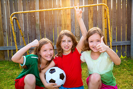 三个姊妹女孩朋友足球赢家足球冠军运动员场地守门员竞赛家庭童年草地团体公园双胞胎女孩们图片