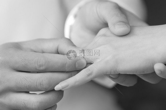 新郎把订婚戒指戴在新娘的手指上婚姻丈夫宝石传统男人婚礼女性男性钻石情感图片