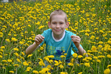 男孩在荒野中的空地上花朵杂草年轻人男生植物孩子草本植物图片