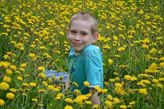 男孩在荒野中的空地上花朵植物年轻人男生草本植物杂草孩子图片