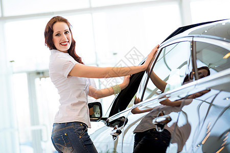 站在汽车旁边的年轻妇女合同客户经销商车库职业运输男人交易协议推销员图片