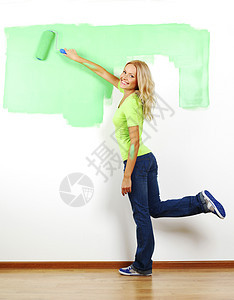 妇女在墙上涂油漆女孩项目别针女性房子画家设计师快乐微笑生活图片
