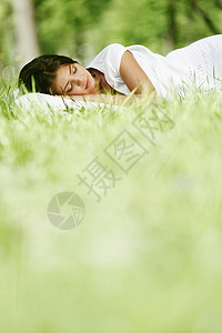 睡在草地上的女人女性自由睡眠公园枕头绿色场地女孩毯子白色图片