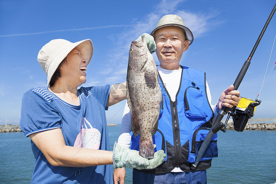 快乐的年老夫妇钓鱼和展示大粉丝图片