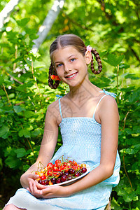 女孩吃樱桃享受女性孩子花园浆果甜点水果微笑童年快乐图片