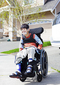 坐在轮椅上快乐的残疾小男孩孩子混血儿微笑晴天医疗幼儿园男性乐趣混血需求图片