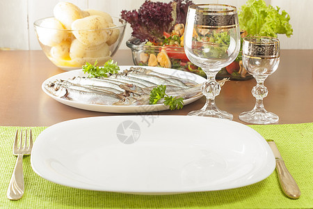 配有零食的餐桌服务仪器盐渍烹饪土豆食物煮沸酒杯盘子图片