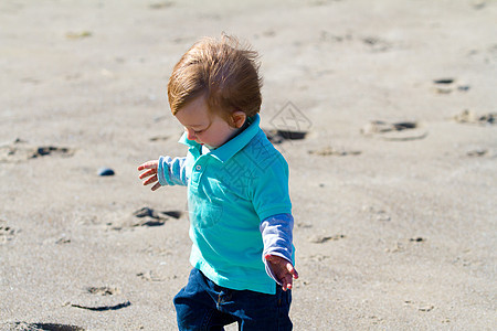 在海滩玩耍的小男孩男生探索孩子乐趣蓝色海洋孩子们海岸衬衫背景图片