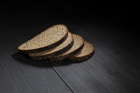 木制桌上的切黑面包小麦食物收获化合物大麦桌子棕色营养粮食碳水图片