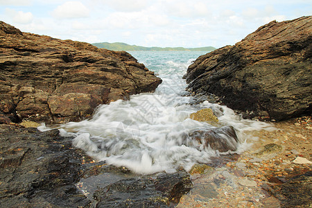 海浪撞击岩石和喷洒水面洪水阳光海岸场景飞溅石头天气冲浪天空海洋图片