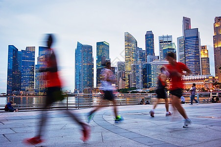 正在运行的新加坡男人跑步热带建筑物日落竞赛中心赛跑者女士男性图片