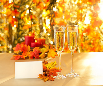 秋天背景前的香槟酒杯招待会用眼镜橙子婚宴树叶卡片长笛奢华酒精名片烛光订婚图片