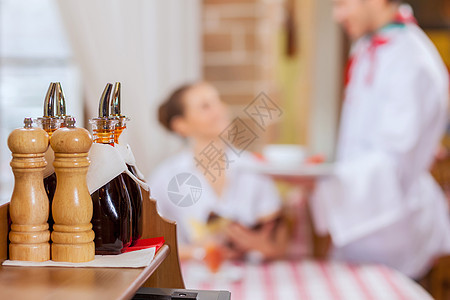 餐馆的年轻女青年游客香料摇床胡椒咖啡服务员敷料餐厅午餐桌子图片