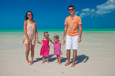 有两个孩子在海滩散步的年轻好家庭图片