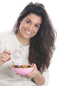 女青年在吃早餐时食用谷物吸引力头发相机微笑水果女士白色图片