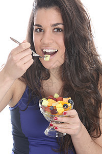 女青年食用新鲜水果沙拉鲜果沙拉微笑吸引力白色相机头发女士图片