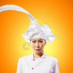 亚裔女性烹饪对抗奶水喷洒蓝色食物牛奶女孩厨房橙子帽子营养胡子围裙图片