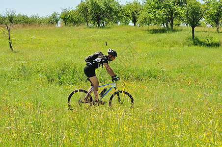 门外骑自行车者男人生活乐趣花朵自然乡村自行车绿色运动晴天图片