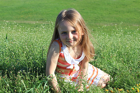 小女孩躺在草地上的肖像享受闲暇童年头发地面孩子们微笑游戏发型孩子图片