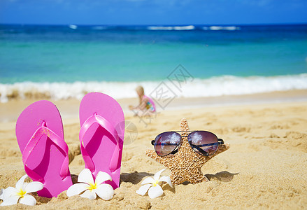 沙沙滩上有太阳眼镜的浮流和海星太阳镜阳光假期海浪花朵凉鞋季节气候旅行热带图片