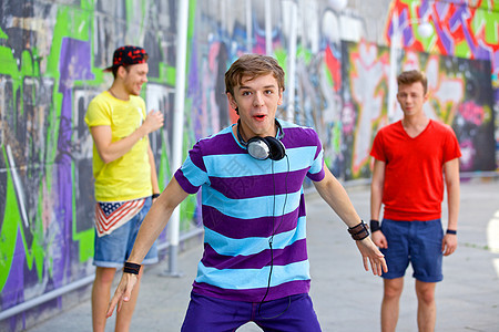 三个年轻朋友幸福快乐滑板男生绘画街道男性友谊蓝色团队衣服青少年图片